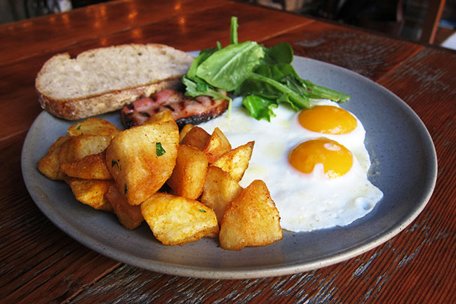 Two fried eggs, bacon, and toast (Jess Fleming / Daily Hive)