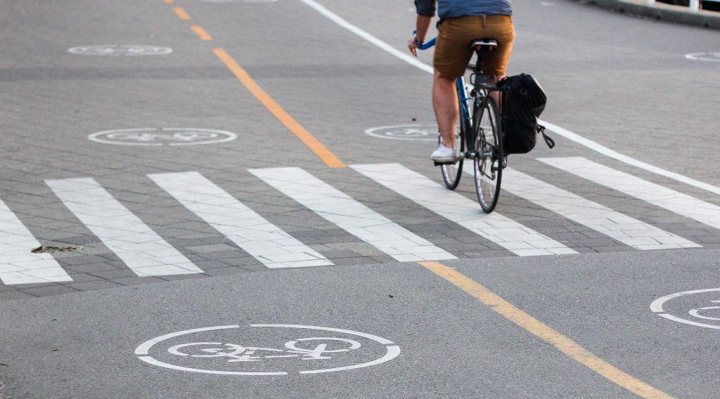 Person biking in bike lane on seawall in Vancouver