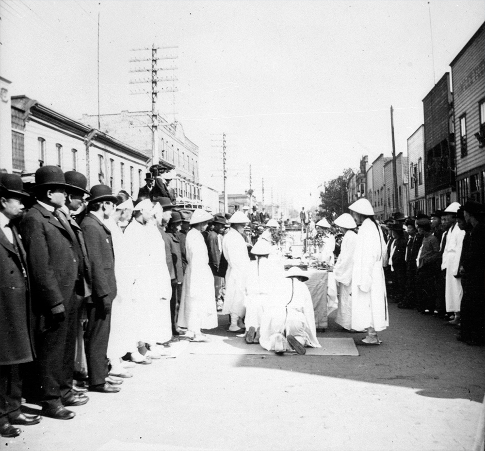 1889: Men don traditional dress for a funeral procession in the middle of Chinatown. (Vancouver Archives)