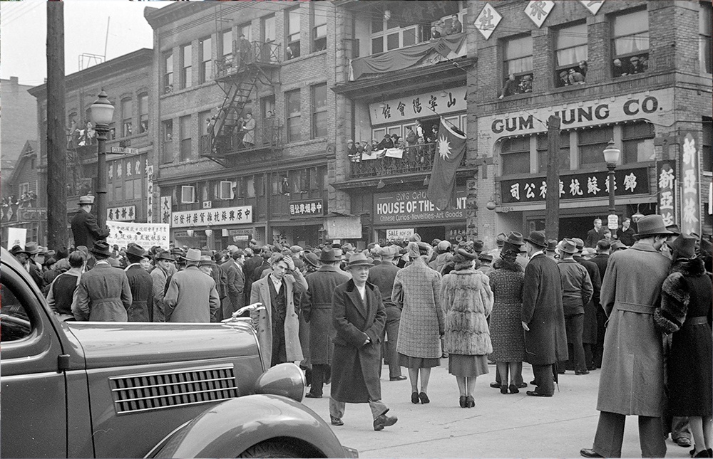 1939: A crowd of both Chinese and European-Canadians has gathered to watch a funeral procession. (Vancouver Archives)