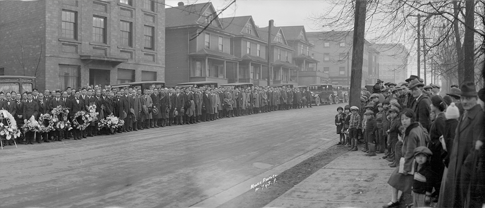 1929: The crowds here have gathered for the funeral procession of a prominent member of the Nikkei community. (Vancouver Archives)