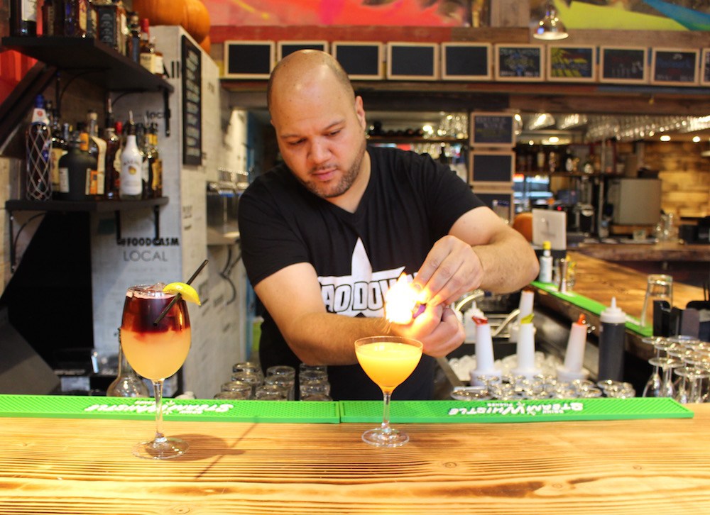 Using the flame to release the oils from the orange peel garnish (Lindsay William-Ross/Daily Hive)