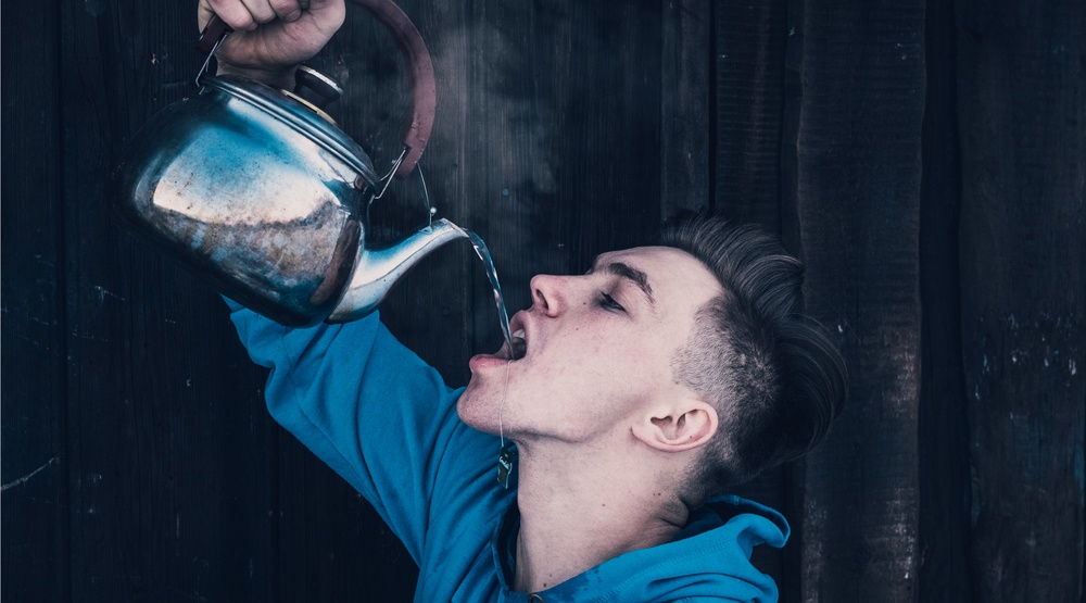 Man drinking tea straight from teapot (Elijah_Sad/Shutterstock)