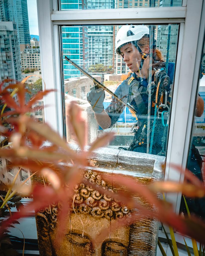 Dominica Myles cleaning windows on a high-rise building (Nicolas Guaiquin)