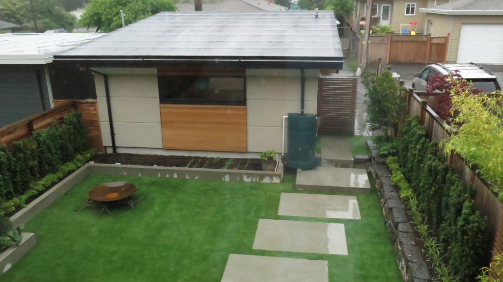 Image: Shed showcasing a green water recollection tank that serves the permeable landscaping.
