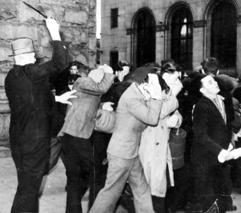 Plain-clothes police officer beating demonstrators with billy clubs during the post office riot on Bloody Sunday in 1938. (B.C. Archives)