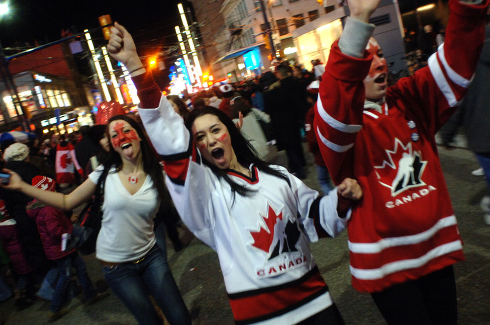 Canadian hockey fans celebrate on the streets of Vancouver after Team Canada won gold at the 2010 Winter Olympic Games on February 28, 2010 (Sergei Bachlakov/Shutterstock)